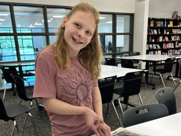 Image of a student smiling in the library
